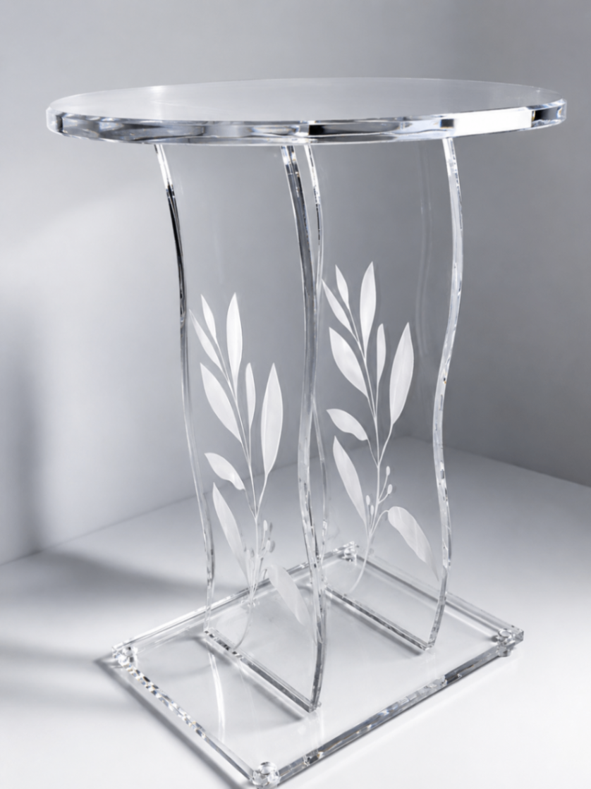 Clear acrylic accent table with etched botanical leaf designs on curved panel legs