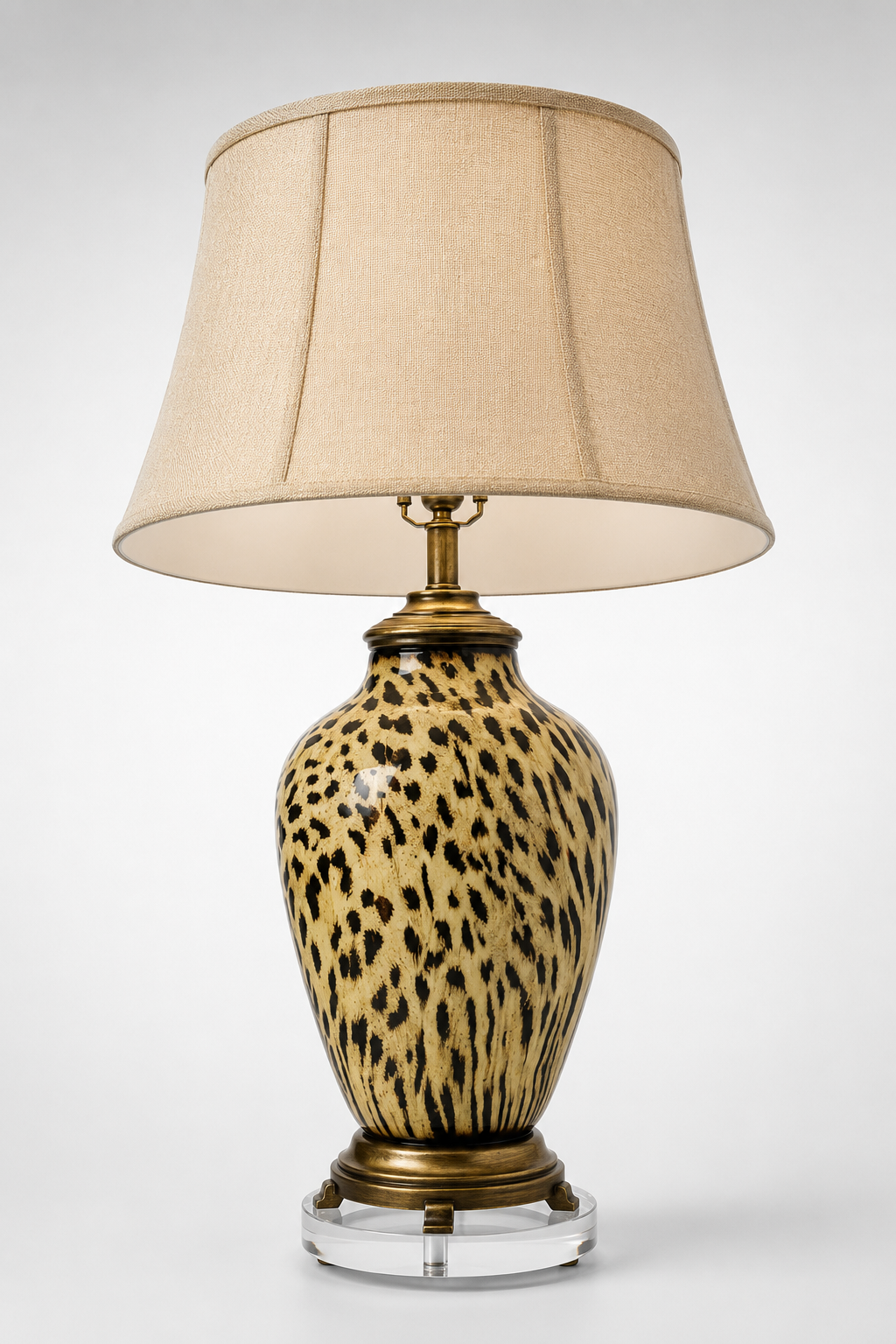 Leopard print vessel table lamp on a clear acrylic base with a tapered linen shade